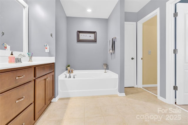 full bathroom with tile patterned flooring, baseboards, a bath, and vanity