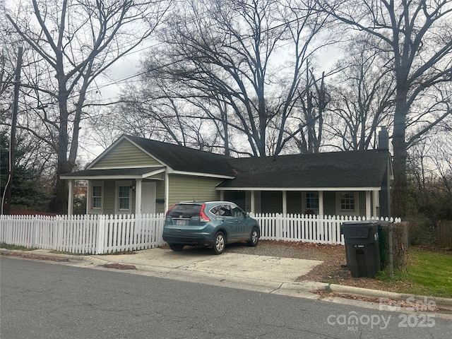 ranch-style home with a shingled roof and a fenced front yard