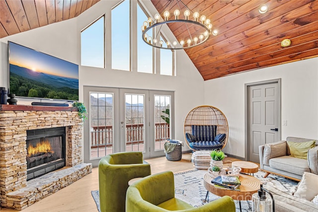 living area with wooden ceiling, wood finished floors, an inviting chandelier, french doors, and a fireplace