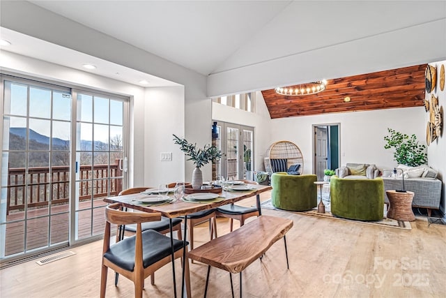 dining space featuring a wealth of natural light, lofted ceiling, visible vents, and light wood-style flooring