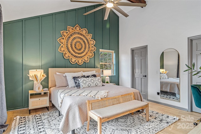 bedroom featuring high vaulted ceiling, ceiling fan, arched walkways, and wood finished floors