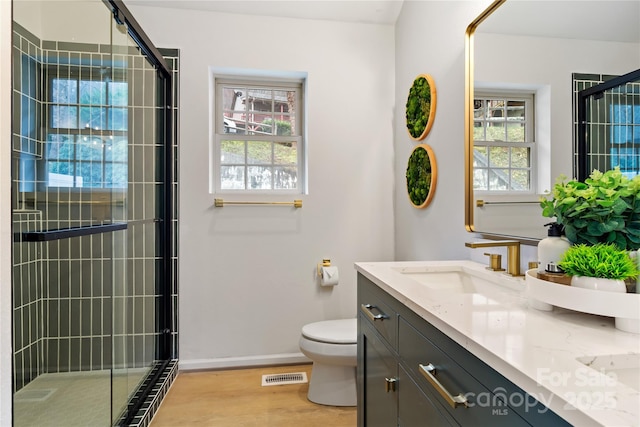 bathroom featuring visible vents, plenty of natural light, a shower stall, and toilet