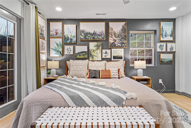 bedroom featuring recessed lighting, visible vents, baseboards, and wood finished floors