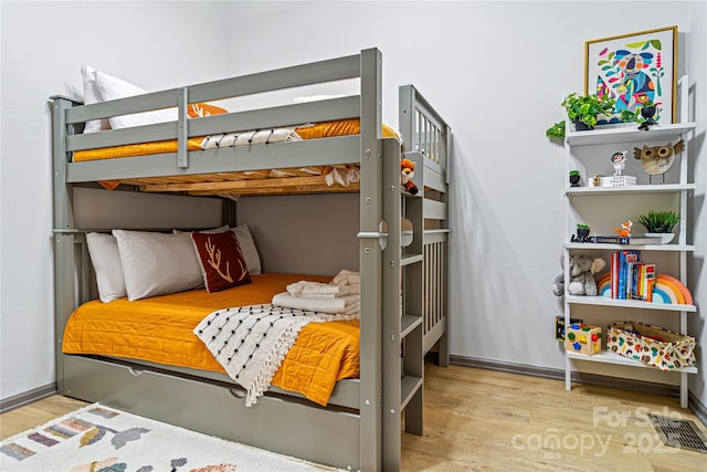 bedroom featuring baseboards, visible vents, and wood finished floors