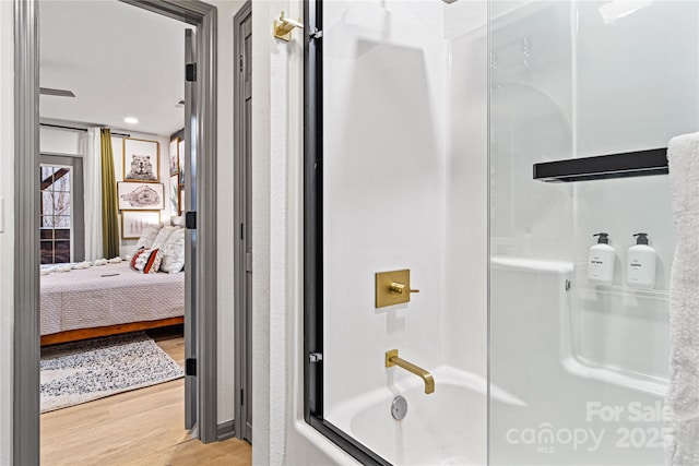 ensuite bathroom with wood finished floors, tub / shower combination, and ensuite bathroom