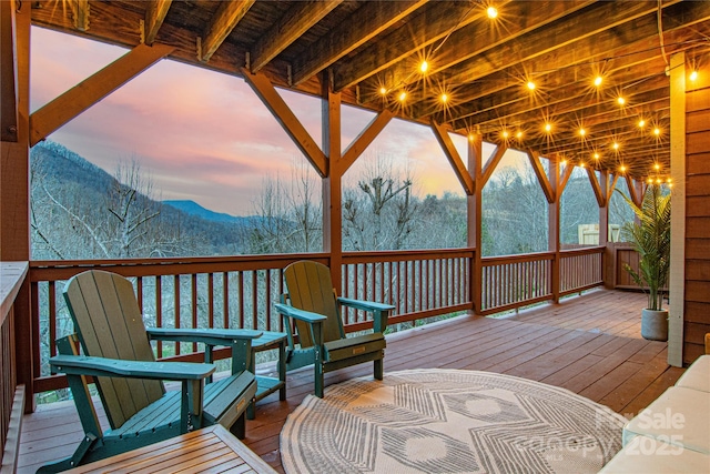 deck at dusk featuring a mountain view