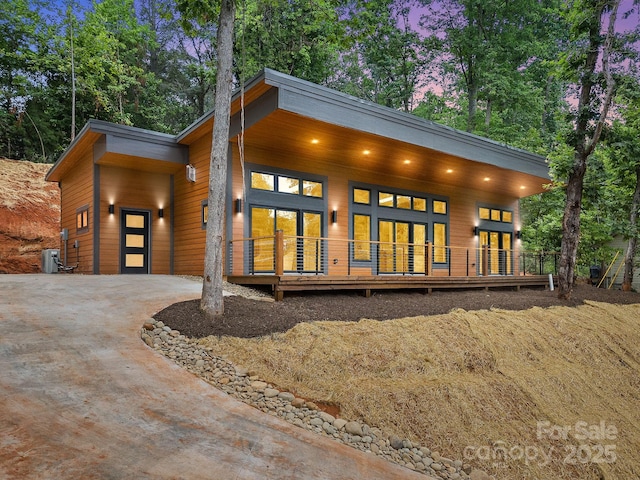 view of front of property featuring driveway and a wooden deck