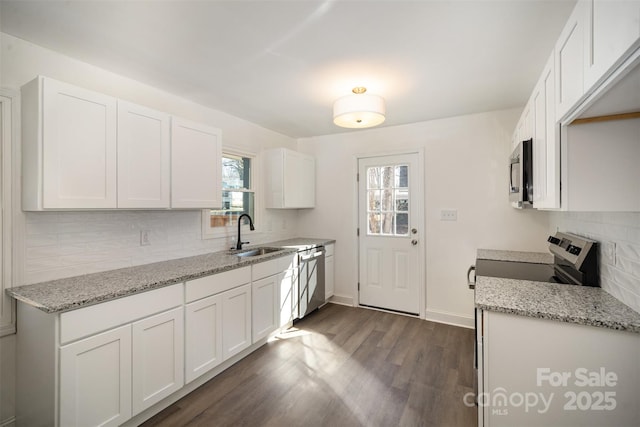 kitchen featuring stainless steel appliances, white cabinetry, a sink, and dark wood-style floors