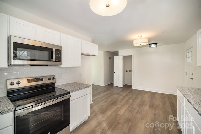 kitchen with light stone countertops, appliances with stainless steel finishes, and white cabinets