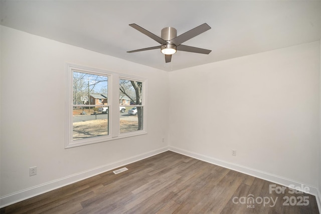 unfurnished room featuring a ceiling fan, dark wood finished floors, visible vents, and baseboards