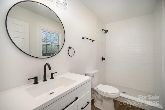 bathroom with a shower stall, vanity, and toilet