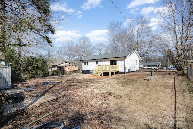 back of property featuring a deck, fence, and stairs