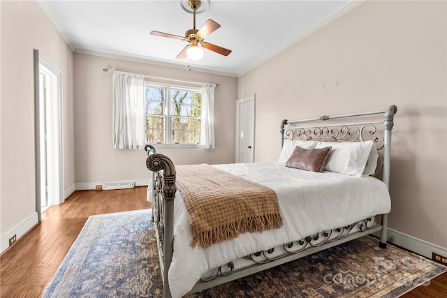 bedroom with baseboards, ornamental molding, and wood finished floors