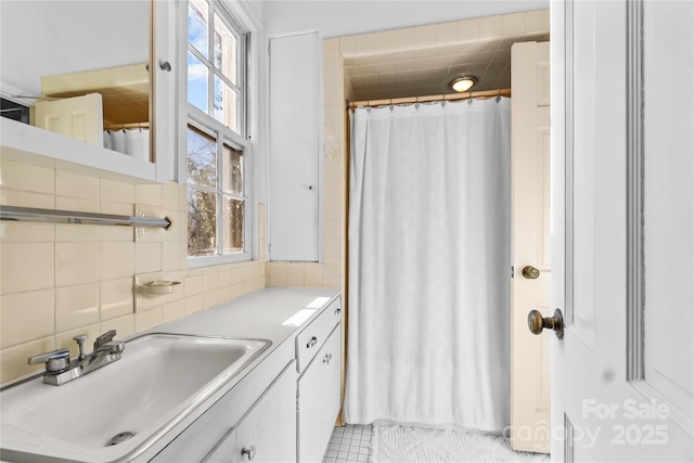 bathroom featuring curtained shower, vanity, and decorative backsplash