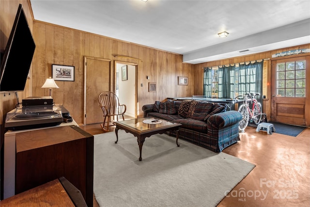 living area with visible vents and wooden walls