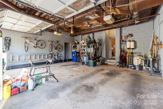 garage with concrete block wall and a garage door opener