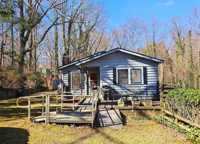 view of front of house featuring fence, a chimney, and a wooden deck