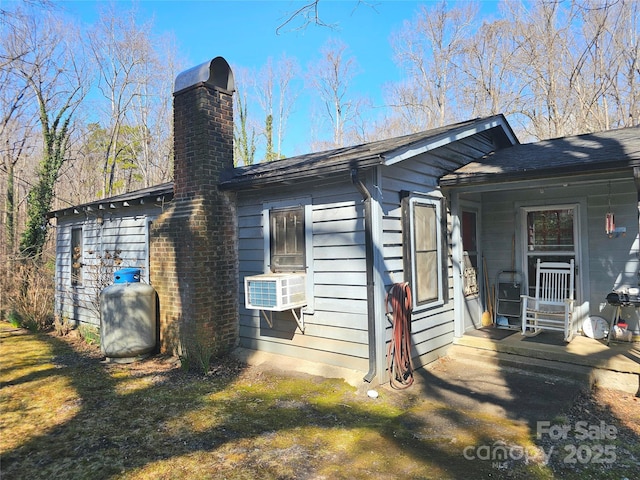 view of home's exterior with cooling unit, a yard, and a chimney