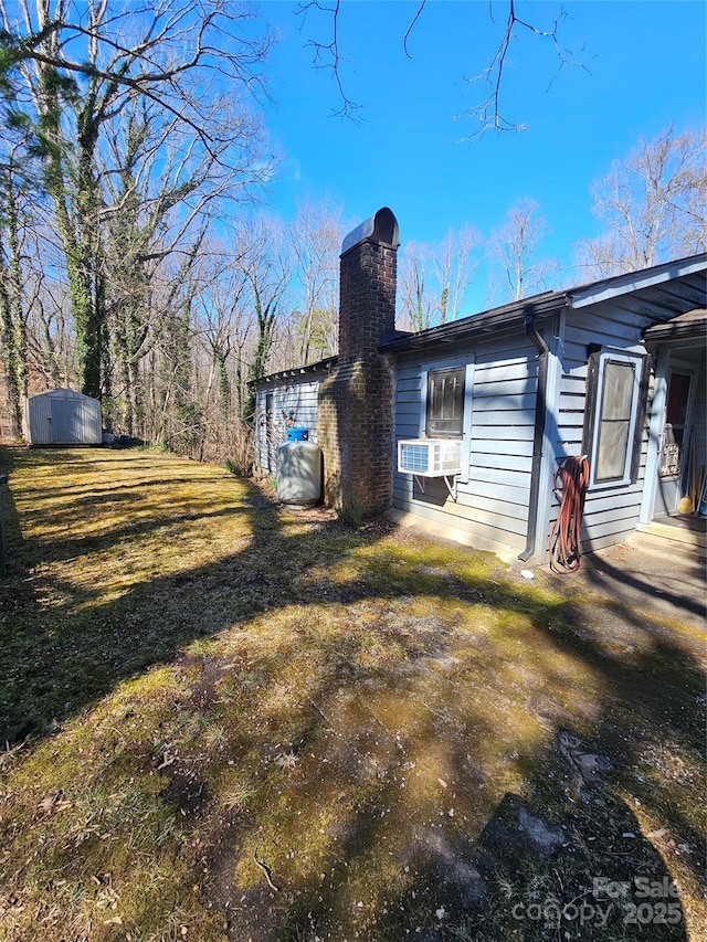 view of property exterior featuring a yard, a chimney, and cooling unit