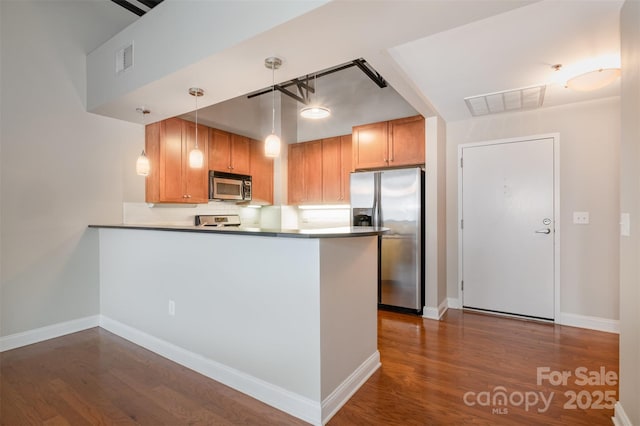 kitchen with appliances with stainless steel finishes, visible vents, hanging light fixtures, and a peninsula