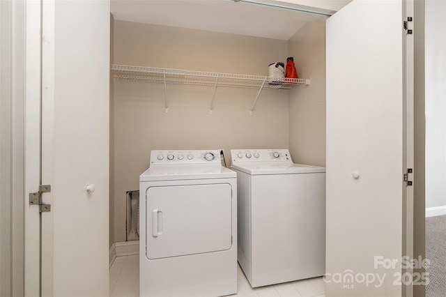 laundry area with laundry area, washer and dryer, and light tile patterned flooring