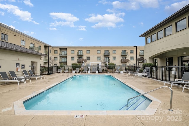 pool with a patio and fence