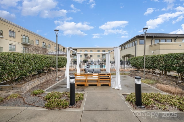 surrounding community with fence and an outdoor hangout area