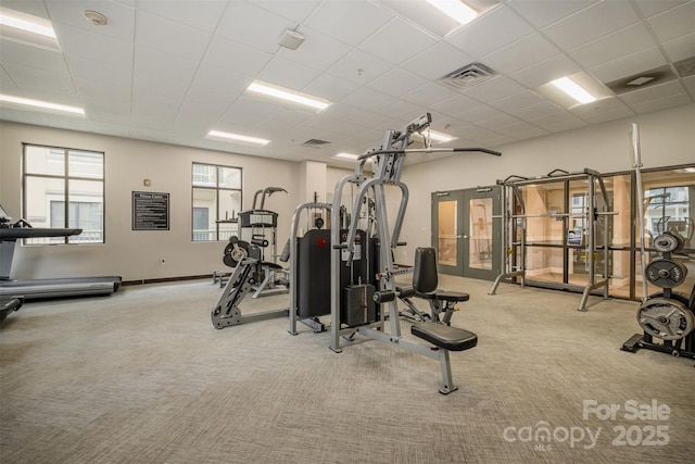 gym with light carpet, baseboards, visible vents, and a drop ceiling