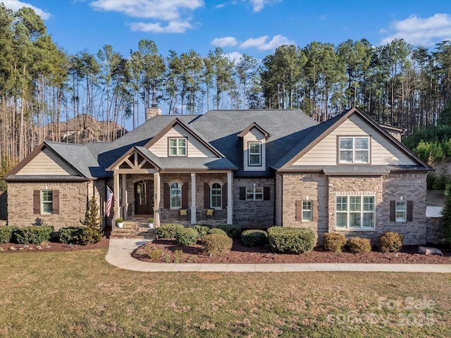 craftsman-style home featuring brick siding, a chimney, and a front lawn