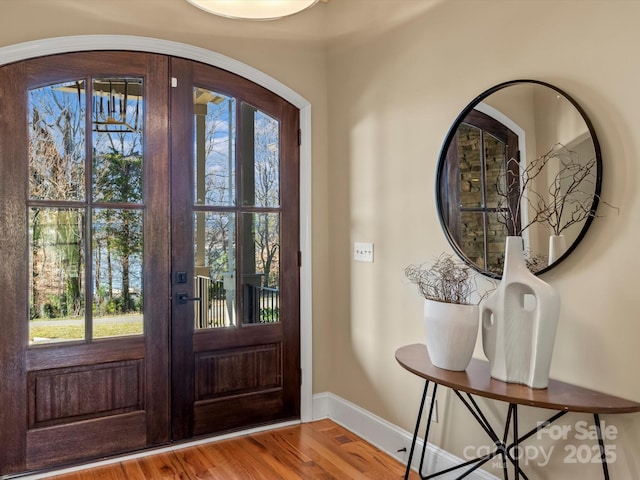 foyer entrance with french doors, wood finished floors, and baseboards