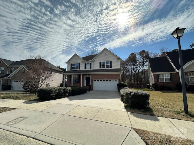 traditional-style house featuring a garage, concrete driveway, brick siding, and a front lawn