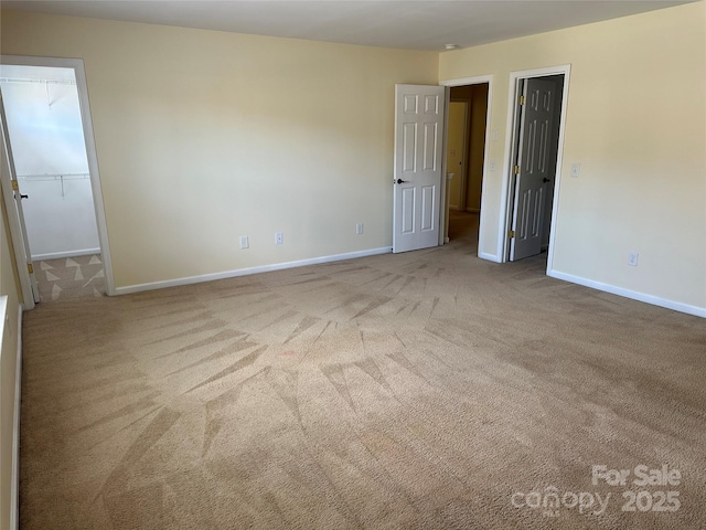 unfurnished room with light carpet and baseboards