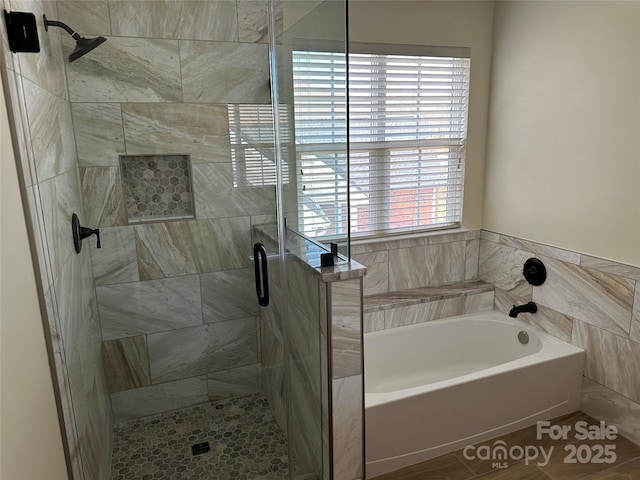 bathroom featuring a stall shower and a garden tub