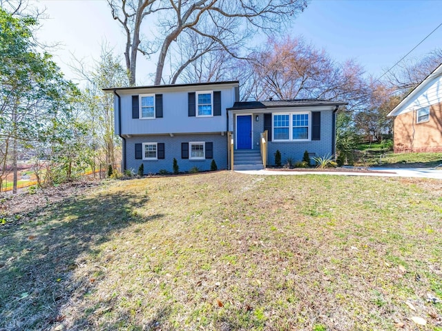 split level home with brick siding and a front lawn