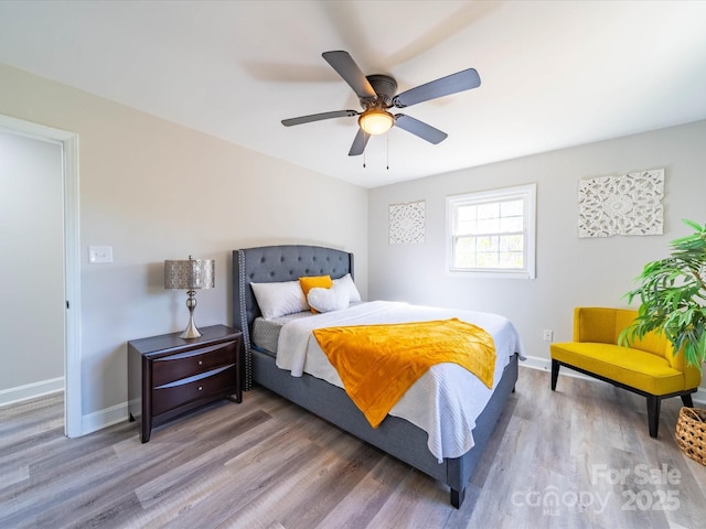 bedroom featuring ceiling fan, baseboards, and wood finished floors