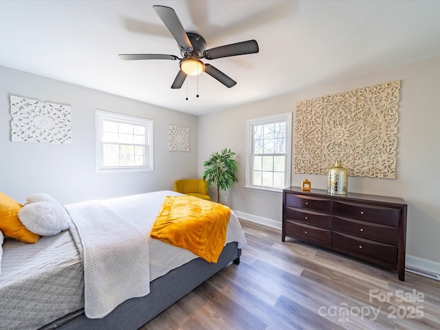 bedroom with multiple windows, dark wood finished floors, visible vents, and baseboards