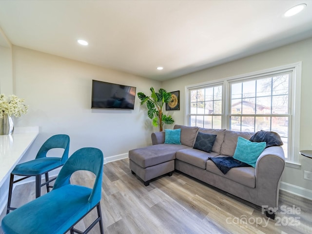 living room with light wood finished floors, recessed lighting, and baseboards