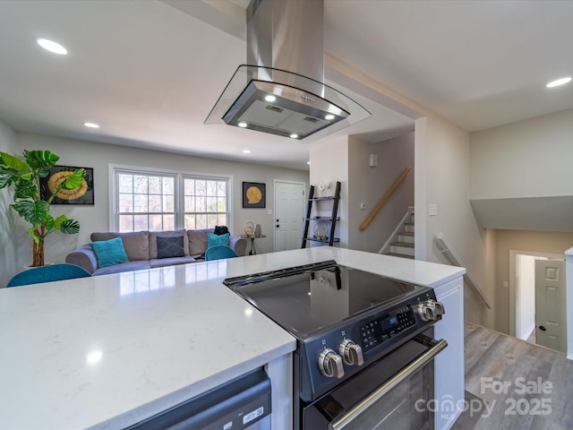 kitchen featuring island exhaust hood, recessed lighting, open floor plan, wood finished floors, and range with electric cooktop