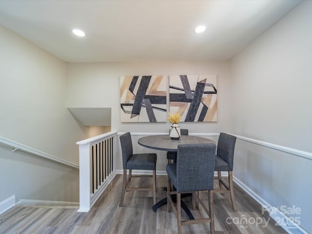 dining room featuring baseboards, wood finished floors, and recessed lighting