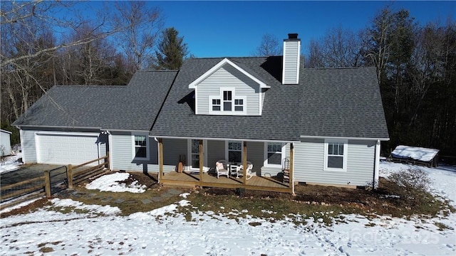 cape cod home with a chimney, a shingled roof, an attached garage, crawl space, and fence