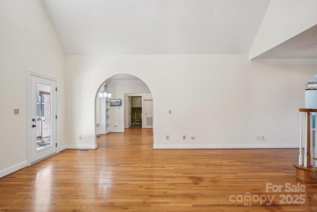 912 Silver Charm Ln, York, SC 29745 - unfurnished living room with light wood finished floors, arched walkways, baseboards, and high vaulted ceiling