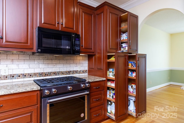 912 Silver Charm Ln, York, SC 29745 - kitchen with gas range, black microwave, tasteful backsplash, light wood-type flooring, and light stone countertops