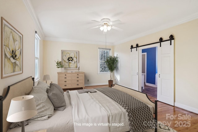912 Silver Charm Ln, York, SC 29745 - bedroom featuring a barn door, wood finished floors, ornamental molding, baseboards, and a ceiling fan