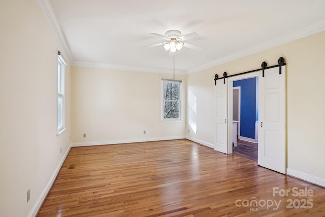 912 Silver Charm Ln, York, SC 29745 - unfurnished room featuring a ceiling fan, wood finished floors, crown molding, baseboards, and a barn door