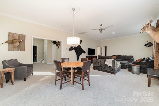 dining area with ornamental molding, a ceiling fan, and light colored carpet