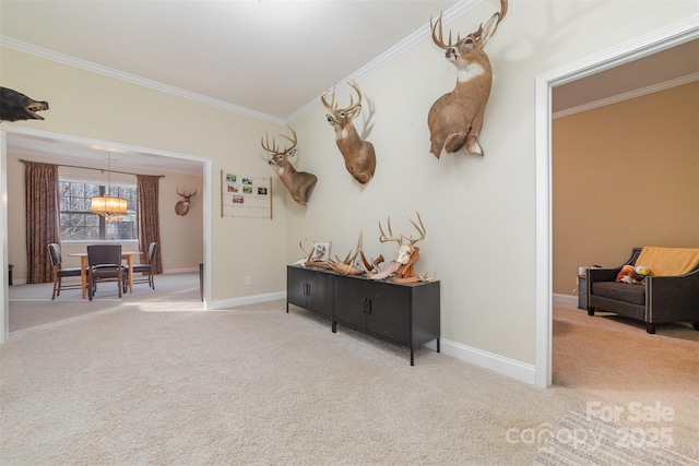 hall with carpet floors, crown molding, baseboards, and an inviting chandelier