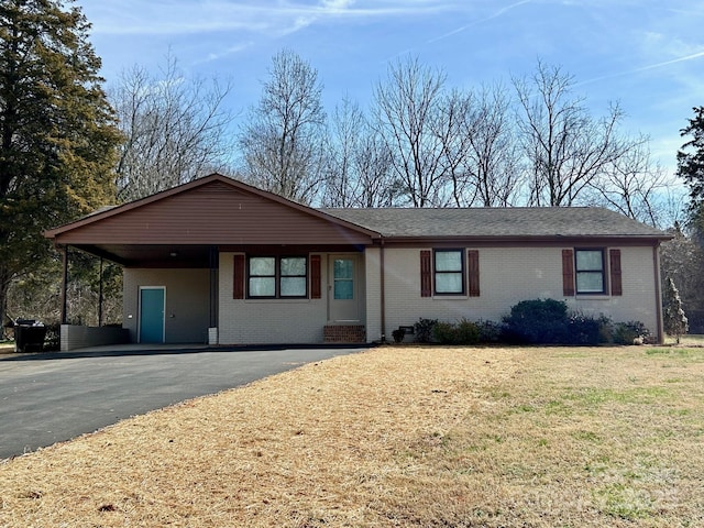 ranch-style home featuring brick siding, driveway, and a front lawn