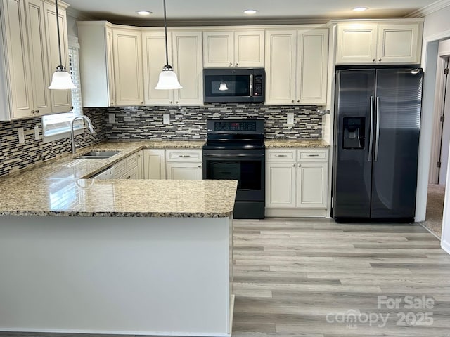 kitchen featuring a peninsula, a sink, refrigerator with ice dispenser, black electric range, and hanging light fixtures