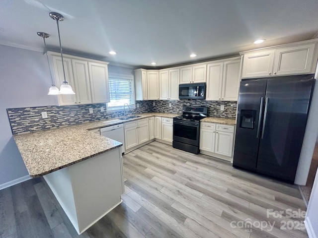 kitchen featuring pendant lighting, black refrigerator with ice dispenser, a sink, range with electric cooktop, and a peninsula