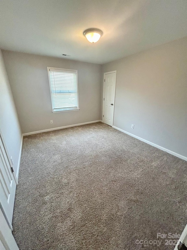 spare room featuring carpet and baseboards